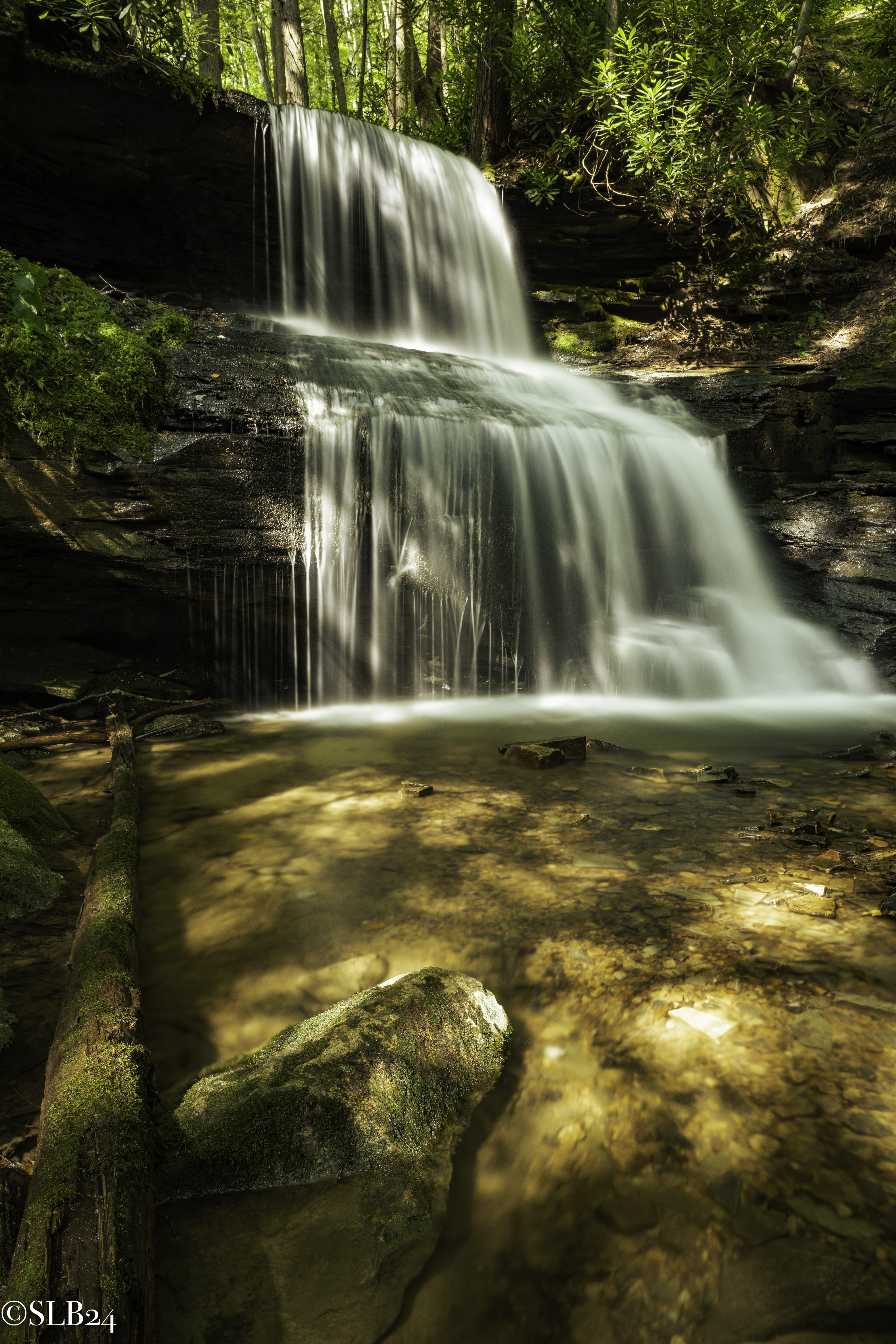 Light speckled waterfall deep in the forest
